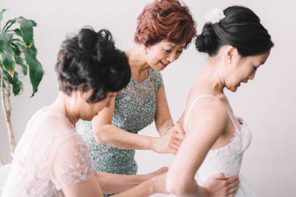 Mothers helping bride get ready