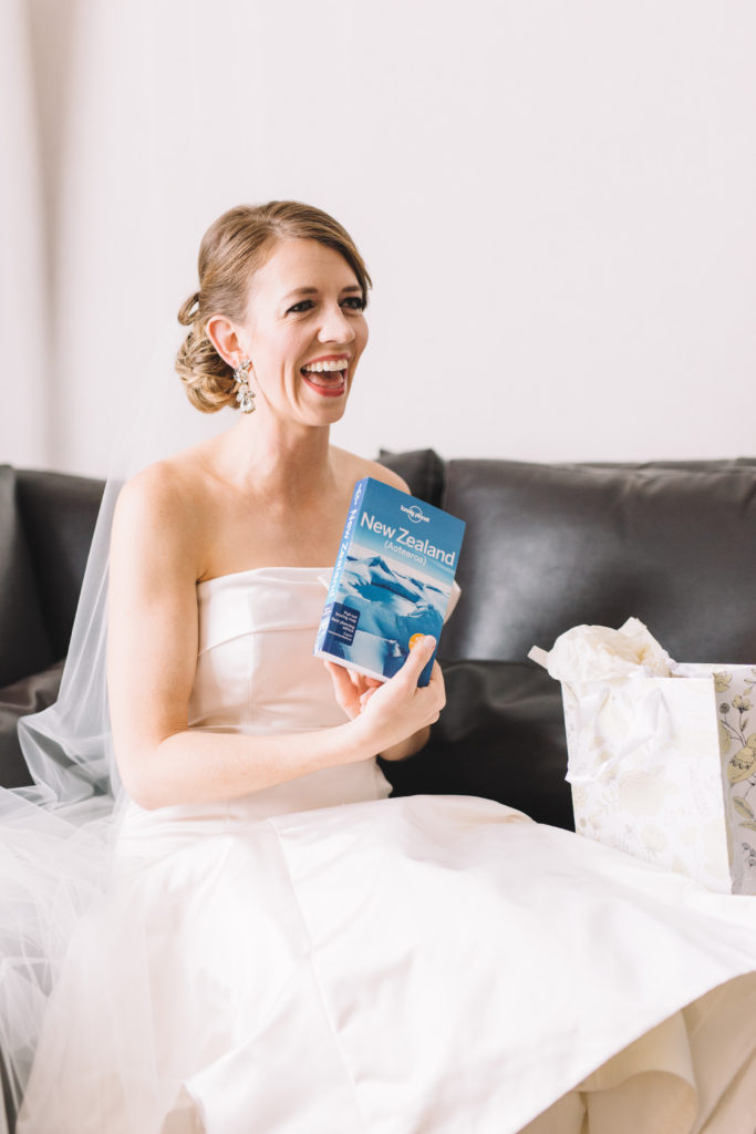 Bride laughing as she opens groom's present