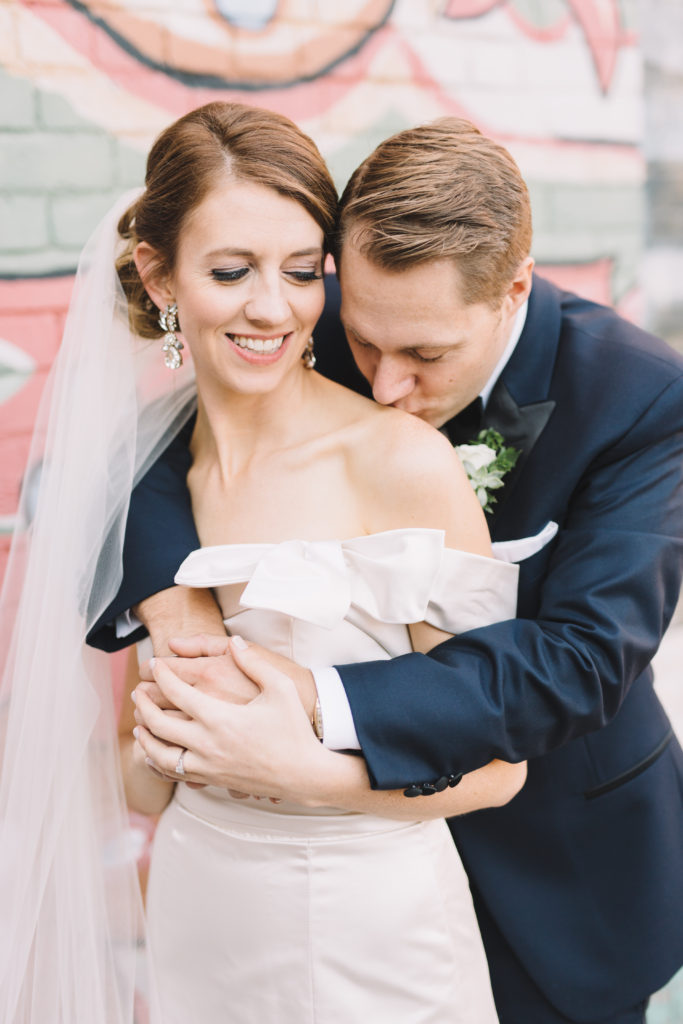 Groom kissing bride's shoulder