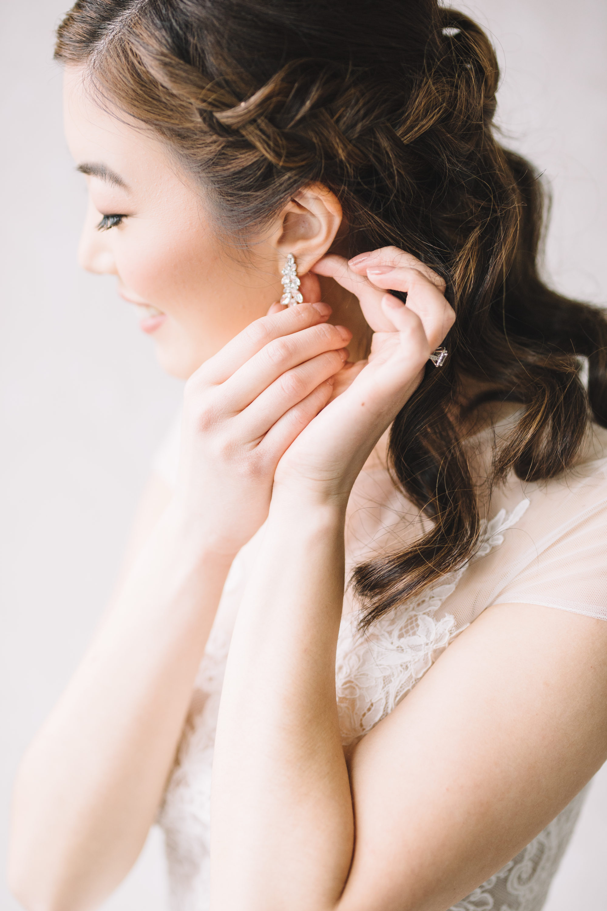 Bride putting on her earrings