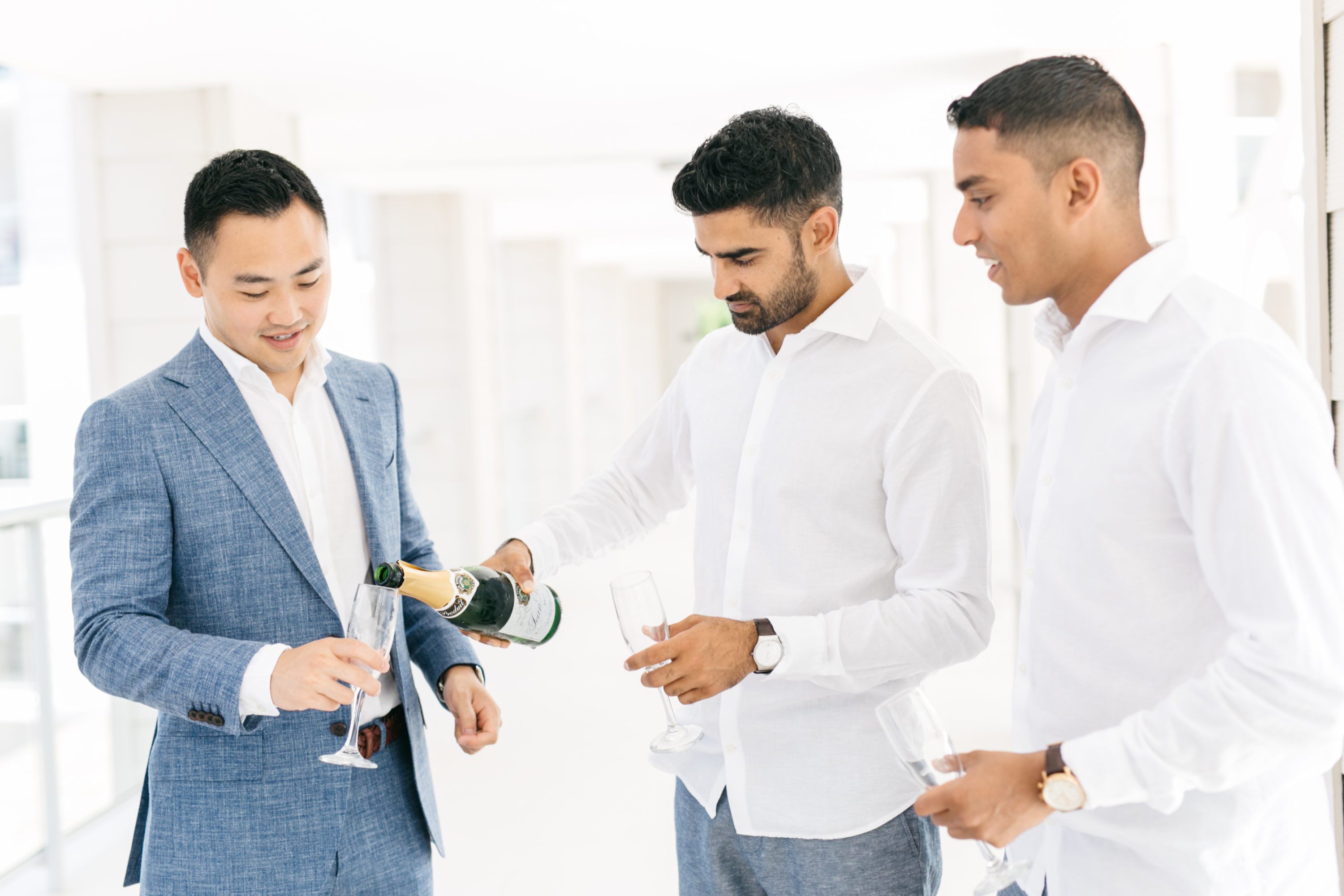Groomsmen pouring champagne