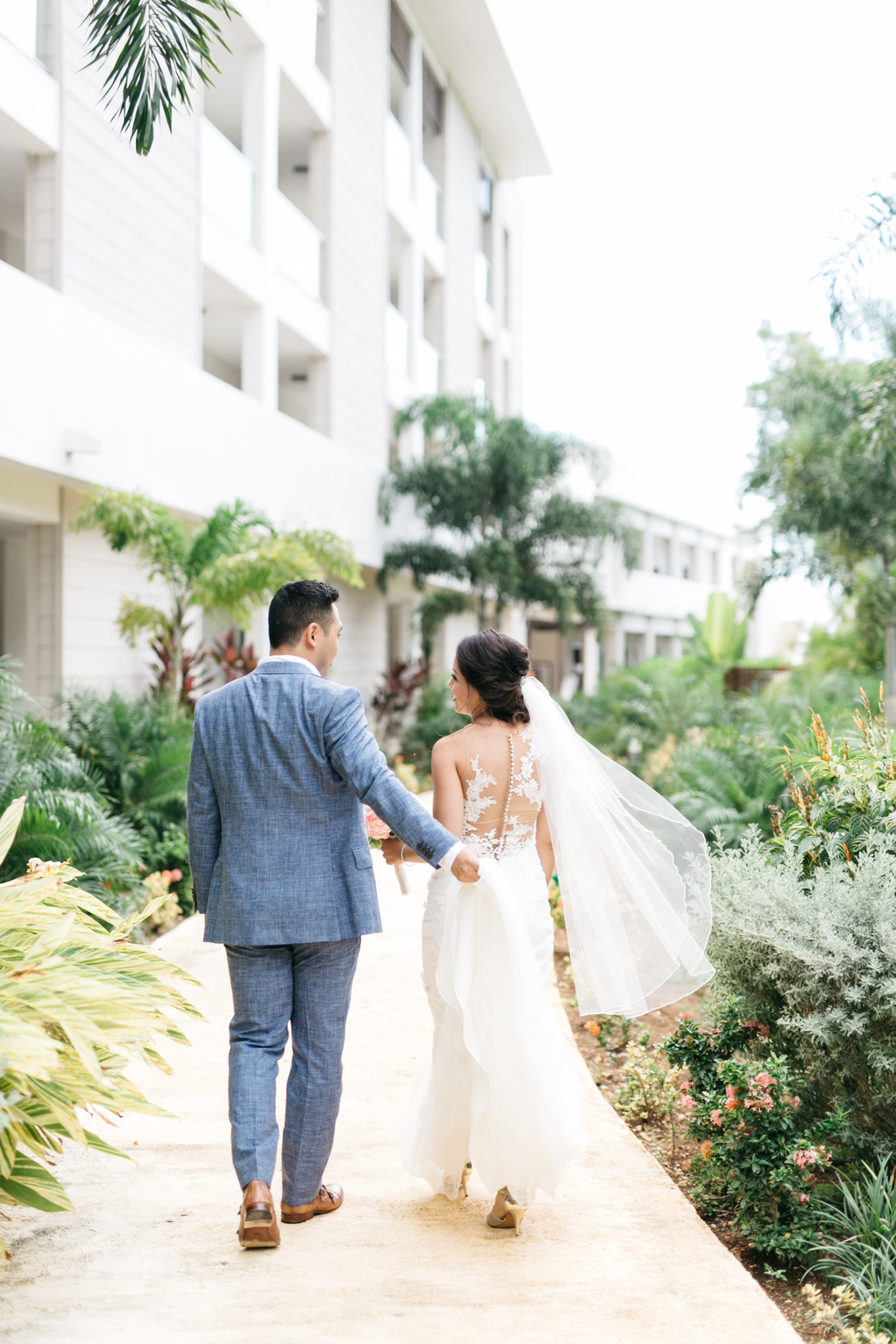 Bride and groom walking through The Royalton White Sands Resort
