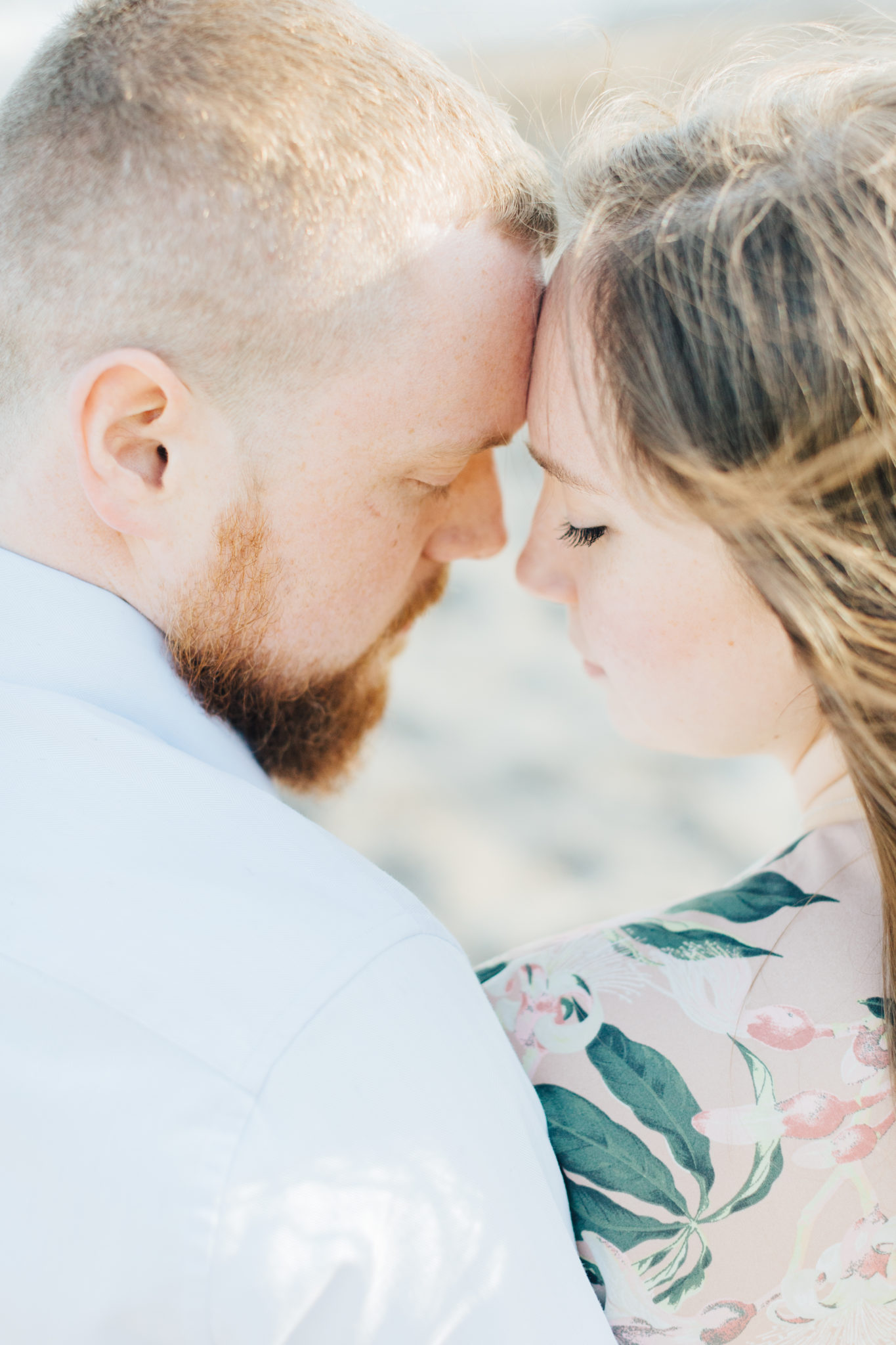 Couple cuddling at engagement session at cherry beach