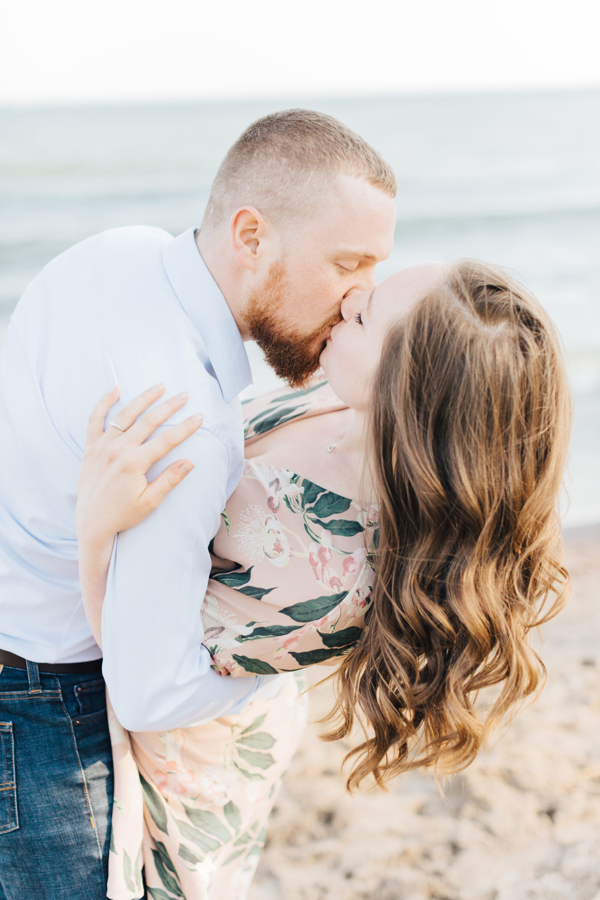 Couple kiss at engagement session at cherry beach