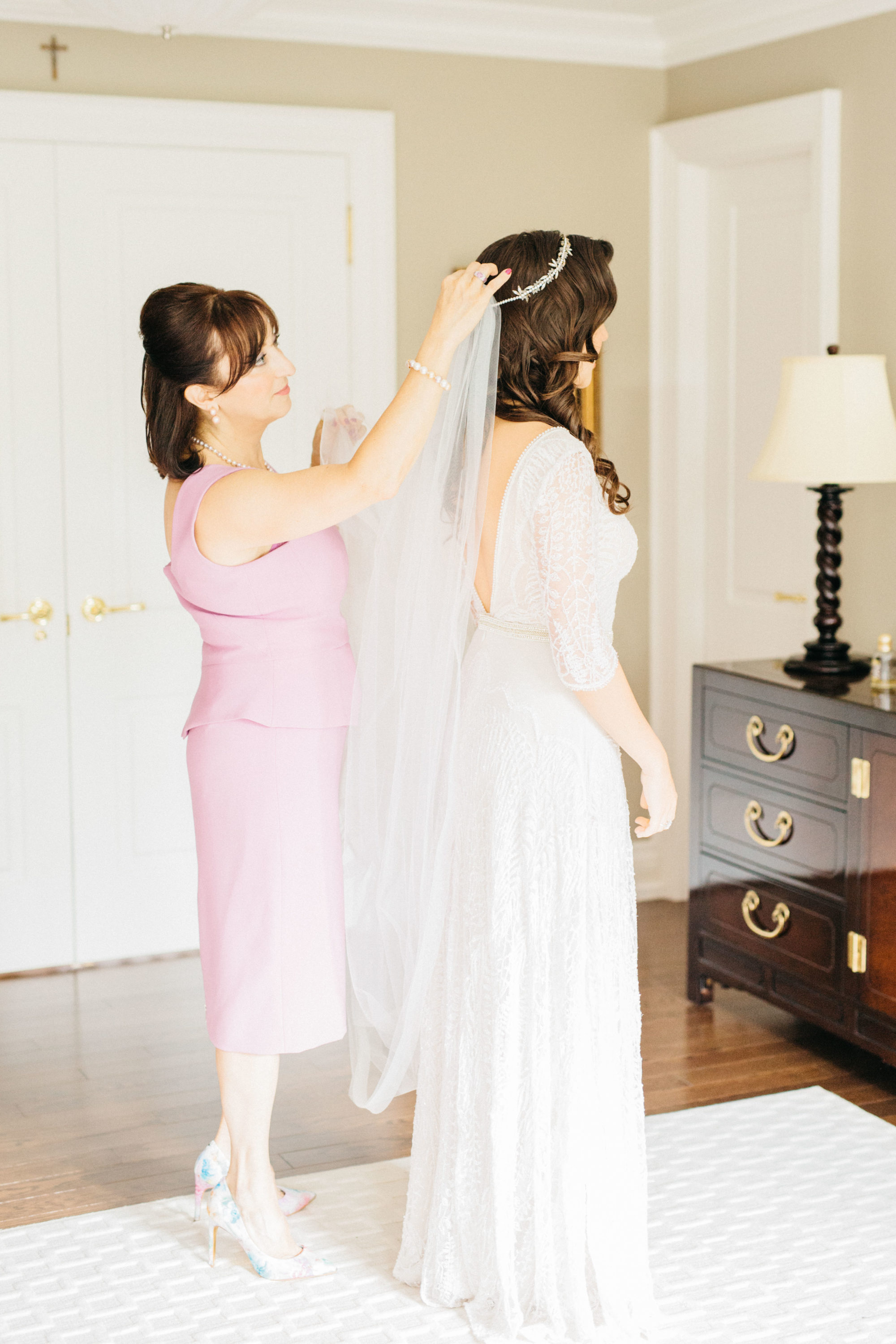 Bride's mother putting on bride's veil