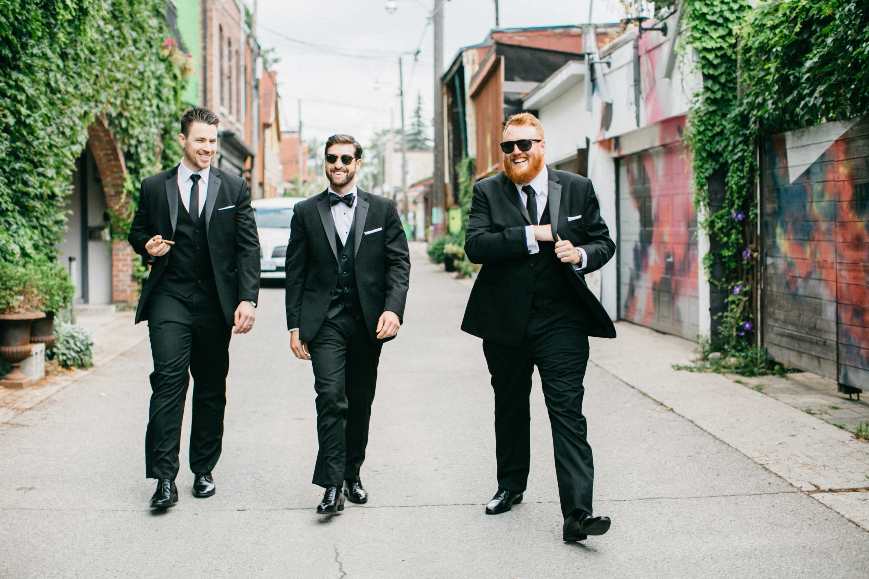 Groom and groomsmen walking down graffiti alley in Toronto