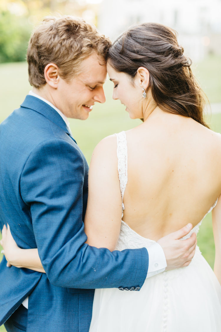 Bride and groom cuddling in backyard
