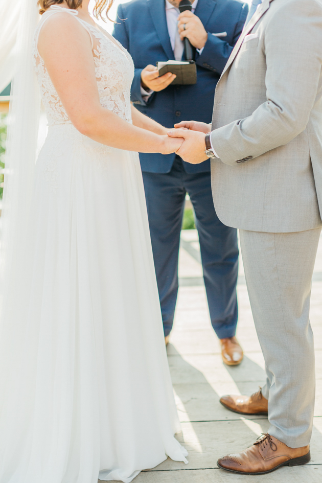 Bride and groom holding hands at ceremony