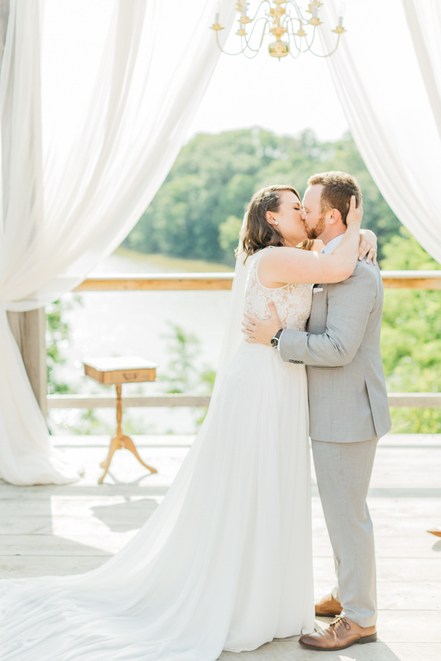 Bride and groom's first kiss at outdoor wedding