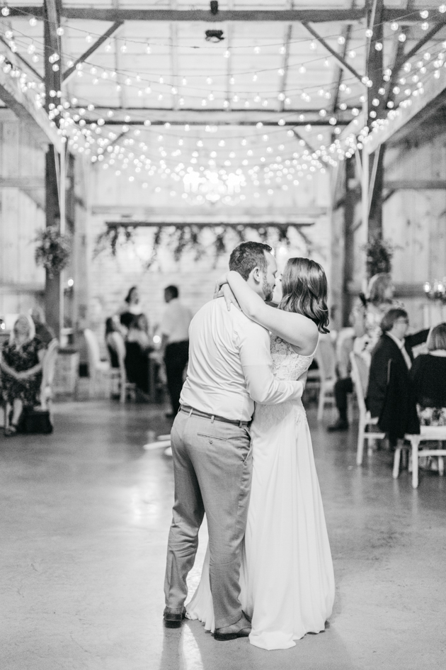 Bride and groom kissing in barn