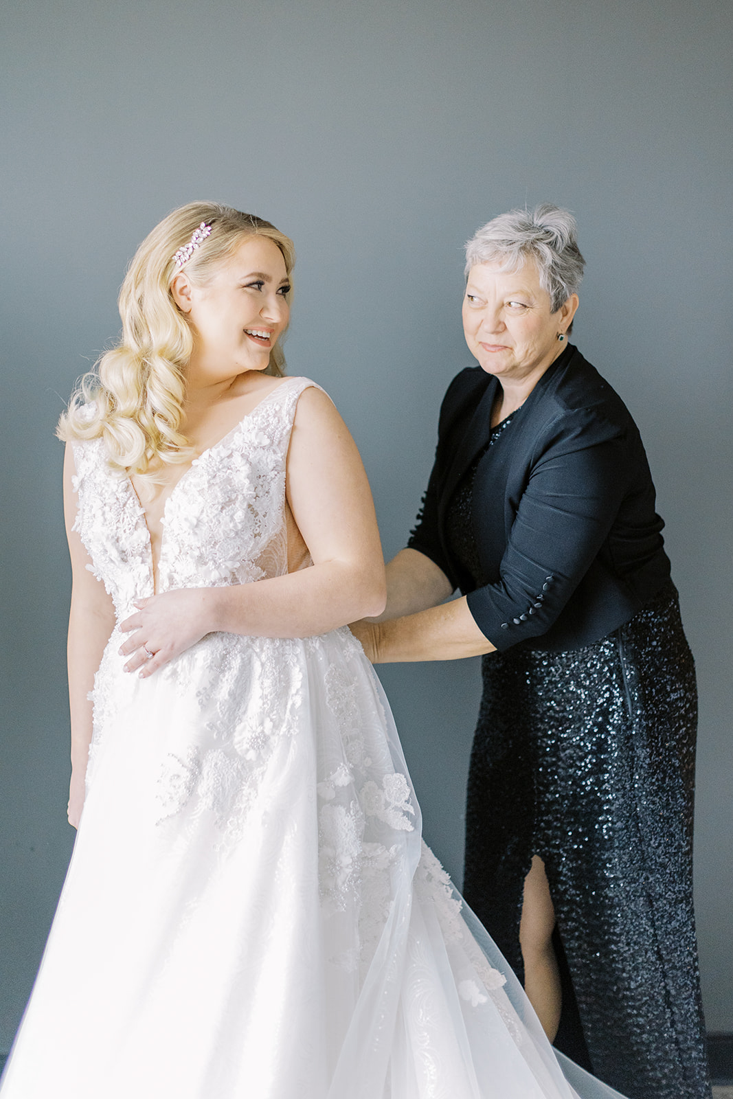 mom helping bride into dress
