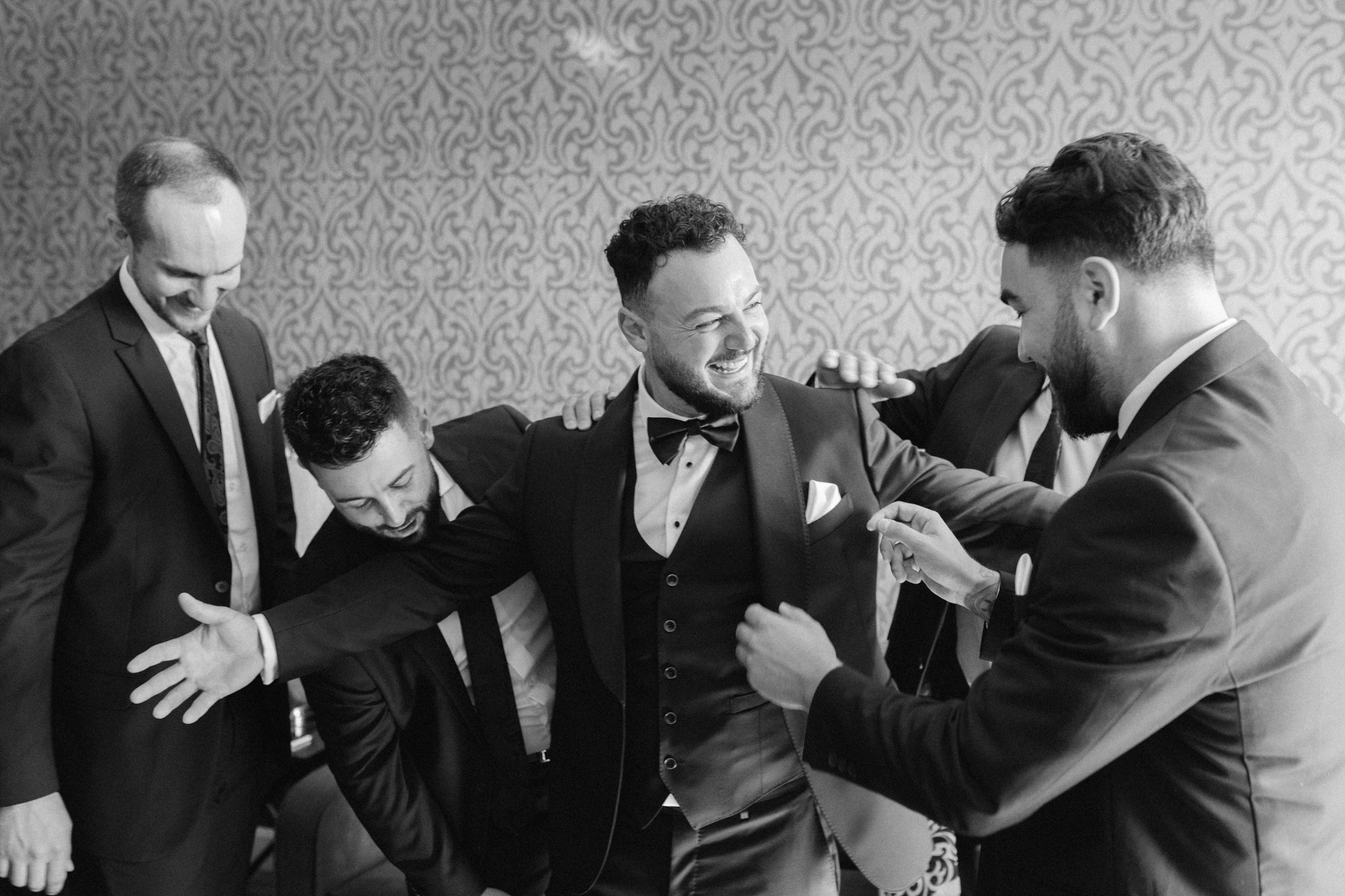 Groomsmen, helping groom, get ready in Cambridge