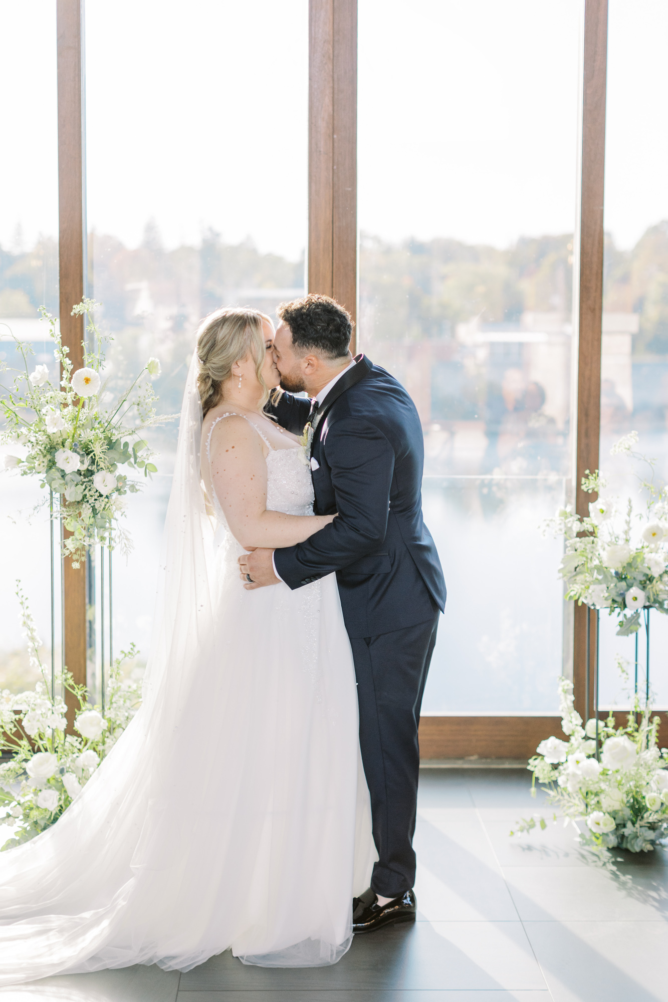First kiss of bride and groom during wedding at Cambridge mill