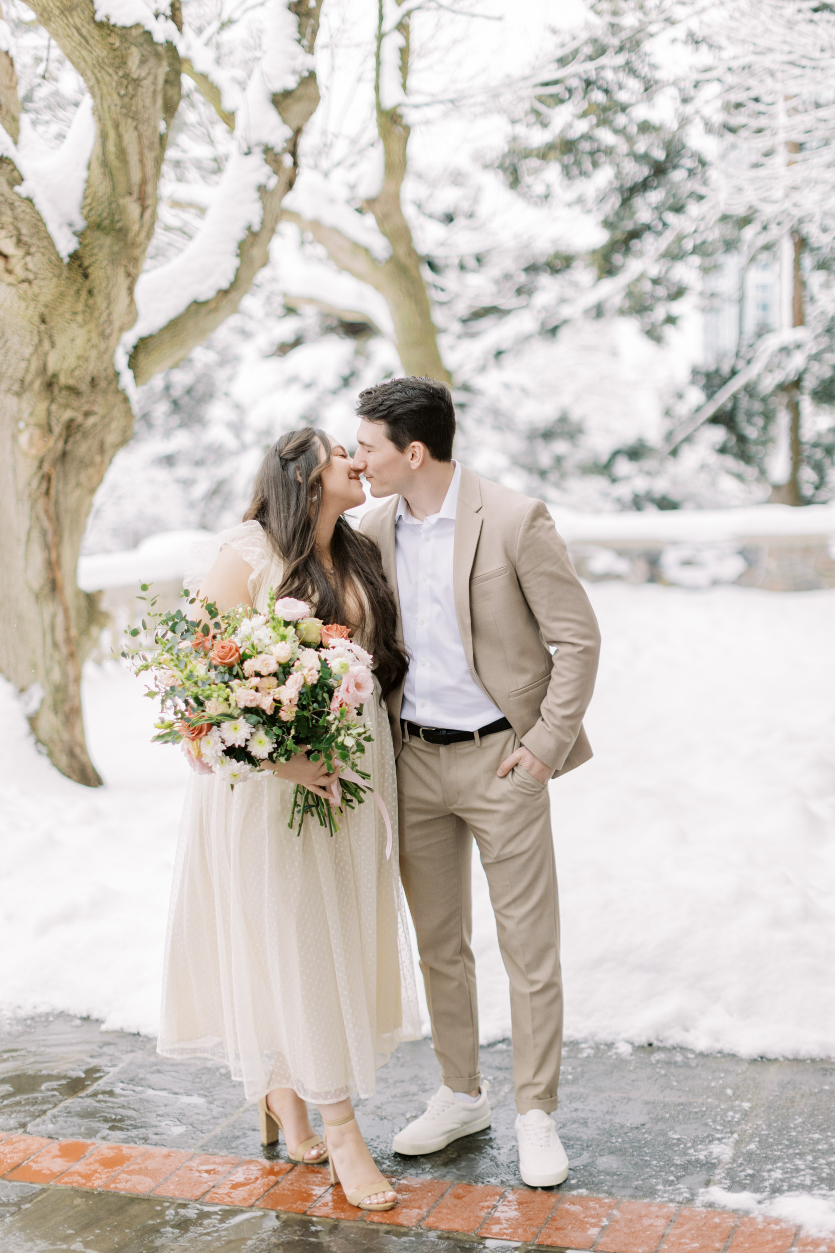 Bride and groom smiling at each other in snowy backyard at Graydon hall
