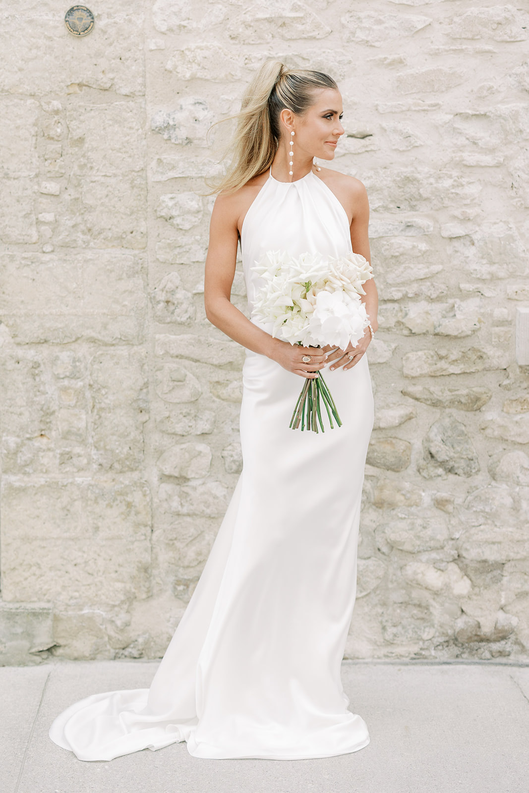 Bride standing with wedding bouquet in a modern wedding dress