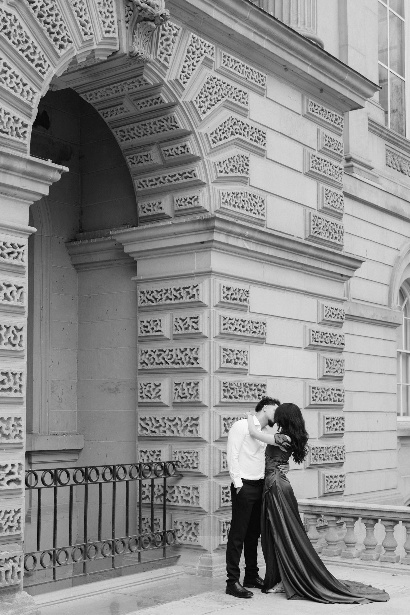Black and white couple kissing far away at Osgoode Hall