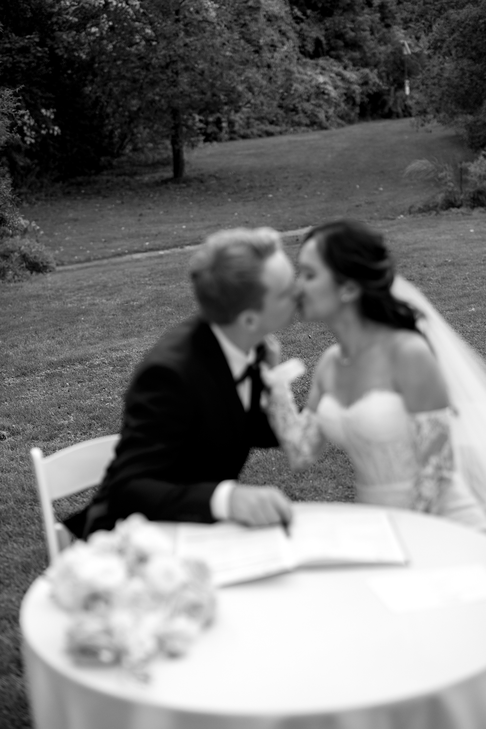 Editorial photograph of bride and groom kissing during ceremony