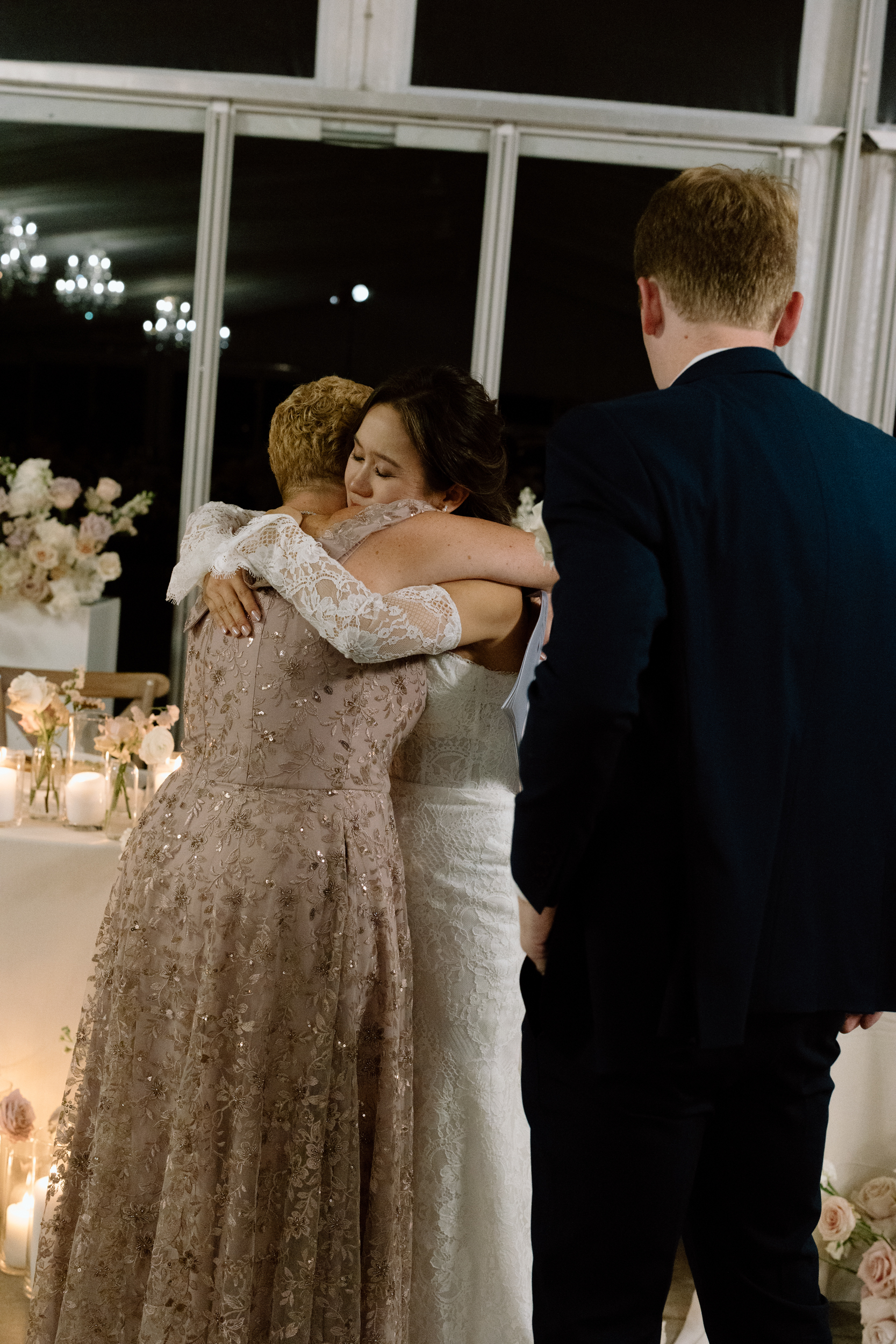 Bride hugging mom at reception